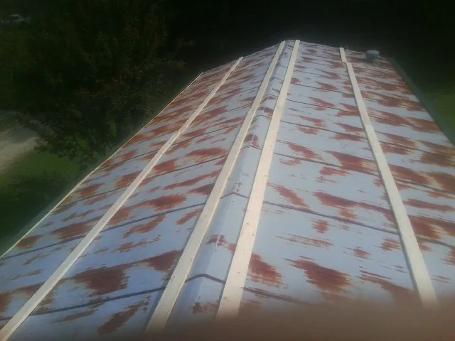 Rusted metal roof panels with new wood purlins before replacement — Storm Damage Roof Repair in Snow Shoe by Roofing Brothers