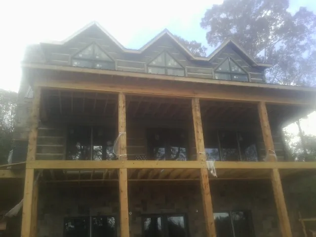 Dormers and porch framing on a large log home under construction — Roof Coating work by our crew in Snow Shoe